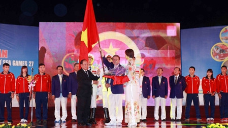 Minister Hoang Tuan Anh (left) presents the national flag to Lam Quang Thanh, head of the Vietnam sports delegation 