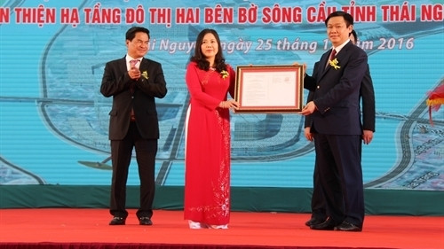 Deputy PM Vuong Dinh Hue (R) hands over the PM’s decision on approving adjustments to the Thai Nguyen master plan by 2035 to the city's leaders (Photo: VNA)
