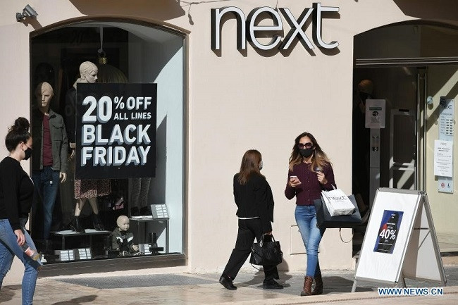 People walk past a shop offering special discounts for Black Friday in Valletta, Malta, Nov. 27, 2020. The special discounts for Black Friday offered by retailers in Malta were not appealing enough to attract lots of customers to step out of their houses amid the COVID-19 pandemic. (Photo: Xinhua)