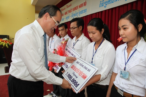the Deputy PM Nguyen Thien Nhan presenting ten scholarships to ten poor students (Photo: VGP)
