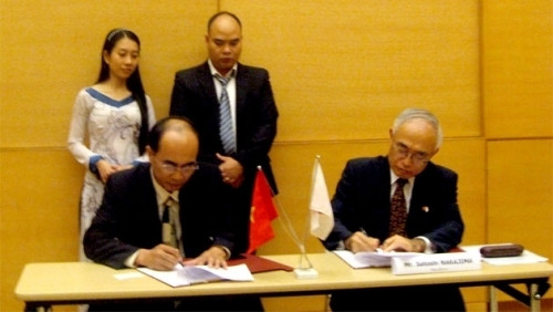 Japanese Consul General in Ho Chi Minh City Satoshi Nakajima (right) signs an agreement with leader of Tay Duc district in Dak Nong province. (Image credit: Nhan Dan)