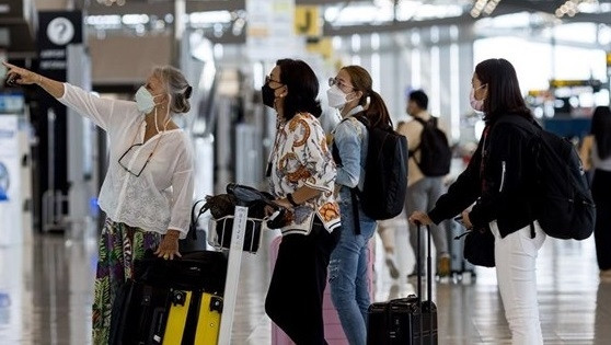 Passengers look at a flight schedule screen at Suvarnabhumi Airport in Bangkok. (Photo: AFP/VNA)