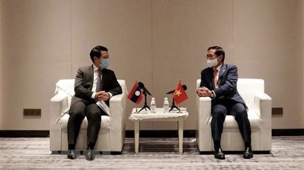 Foreign Ministers Bui Thanh Son of Vietnam (R) and Saleumxay Kommasith of Laos meet in China’s Chongqing city on June 6 (Photo: VNA)