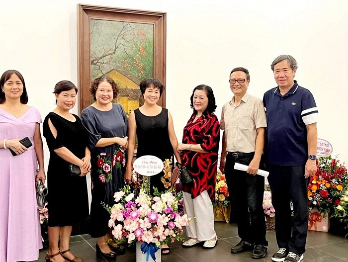 Do Quyen Hoa (central) and visitors at the exhibition (Photo: tuoitrethudo.com.vn)