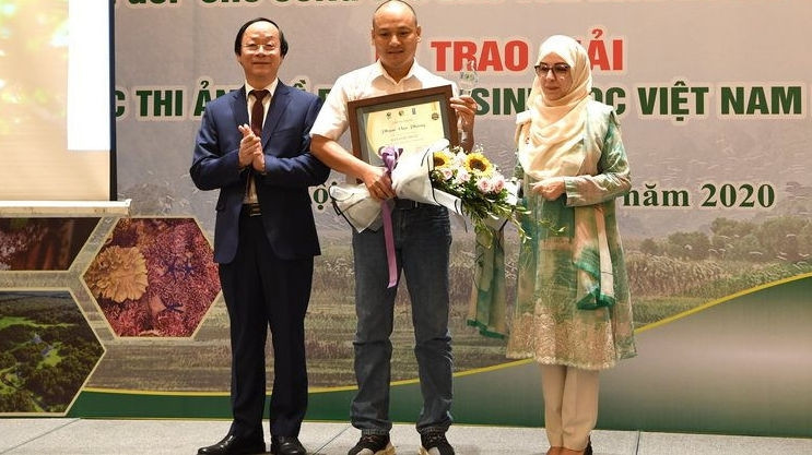 First prize winner Pham Van Phung (C) honoured at the ceremony (Photo: baotainguyenmoitruong.vn)