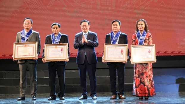 Deputy Prime Minister Vuong Dinh Hue (C) and outstanding businesses at the event 