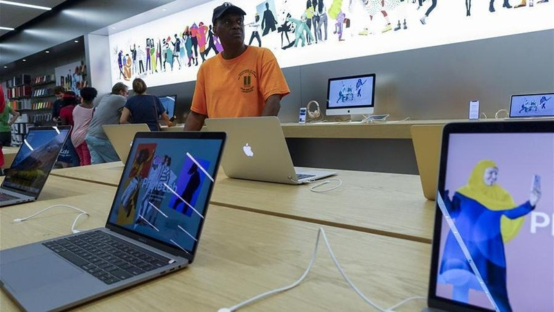 Customers select products at an Apple store in New York, the United States, Aug. 2, 2018. US tech giant Apple became the first American company that saw its market cap hit US$1 trillion in the US history after its shares rose 2.8% to a session high of 207.05 dollars around midday trading on August 2. (Xinhua/Wang Ying)