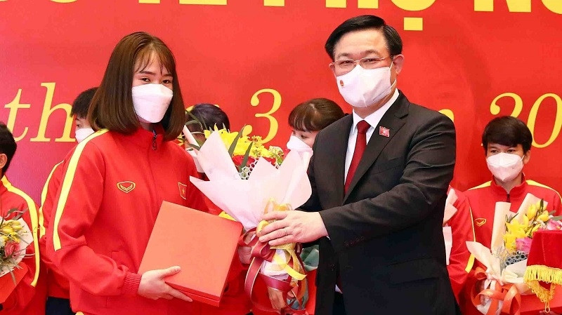 National Assembly Chairman Vuong Dinh Hue present gifts and flowers to female football players. (Photo: VNA)