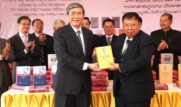 The Communist Party of Vietnam Politburo member Dinh The Huynh hands over works by great thinkers to Lao Vice President Bounnhang Volochith. (Credit: VNA)