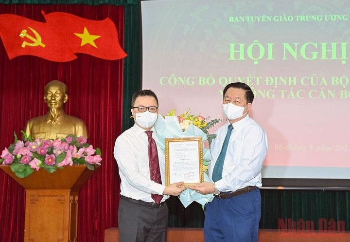 Head of the PCC's Commission for Communication and Education Nguyen Trong Nghia (R) hands over the Politburo's decision and presents flowers to Nhan Dan Editor-in-chief Le Quoc Minh. (Photo: NDO)