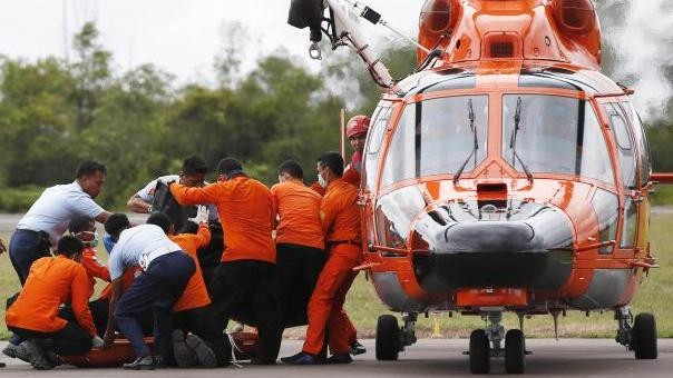 Indonesian Search and Rescue crews unload one of two bodies of AirAsia passengers recovered from the sea at the airport in Pangkalan Bun, central Kalimantan on December 31. (Image credit: Reuters)