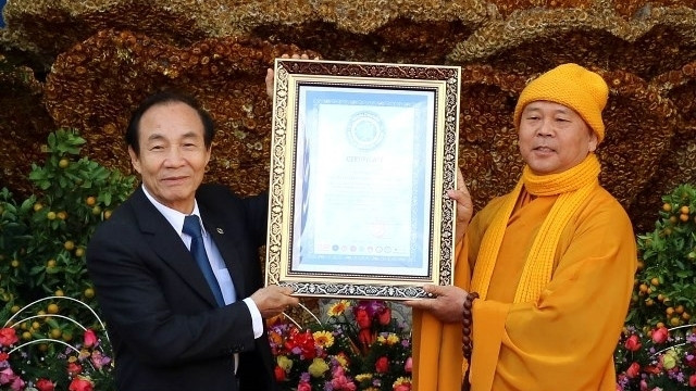 The delegate of Vietnam Book of Records (VietKings) presenting a certificate announcing the new world record for the flower-made Goddess of Mercy statue at Linh Phuoc pagoda, Da Lat city.