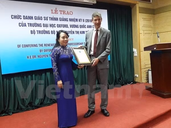Health Minister Nguyen Thi Kim Tien (L) receives the title of visiting professor (Photo: VNA)