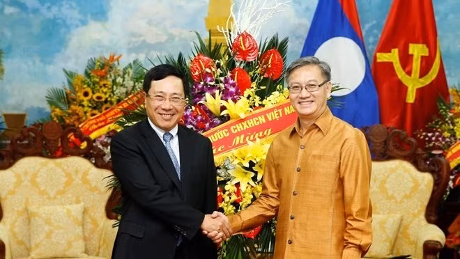 Deputy Prime Minister and Foreign Minister Pham Binh Minh (L) and Lao Ambassador to Vietnam Thongsavanh Phomvihane (Photo: VNA)