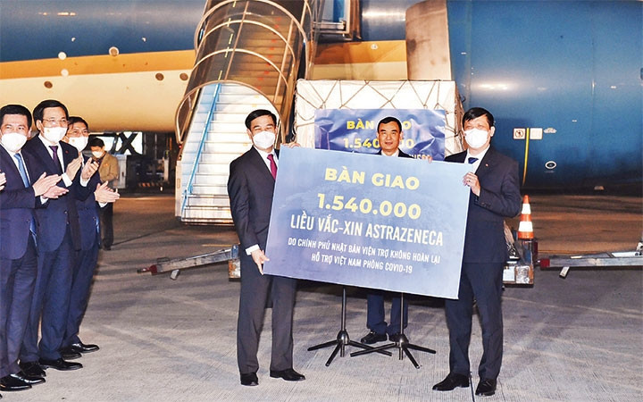 General Phan Van Giang, Politburo member and Minister of National Defence hands over 1.54 million doses of AstraZeneca vaccine to Health Minister Nguyen Thanh Long which is donated by the Japanese Government. (Photo: NHAT BAC)
