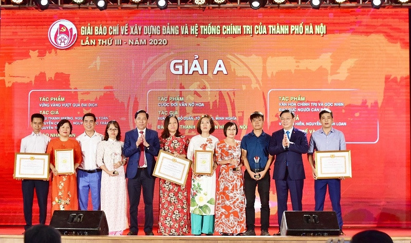 Politburo member and Secretary of the Hanoi Municipal Party Committee Vuong Dinh Hue and Member of the Party Central Committee, Editor-in-chief of Nhan Dan Newspaper Thuan Huu, who is also Deputy Head of the Party Central Committee’s Commission for Communications and Education and Chairman of the Vietnam Journalists’ Association, present A prizes to winners of Hanoi’s third Press Award on Party Building and Political System 2020.