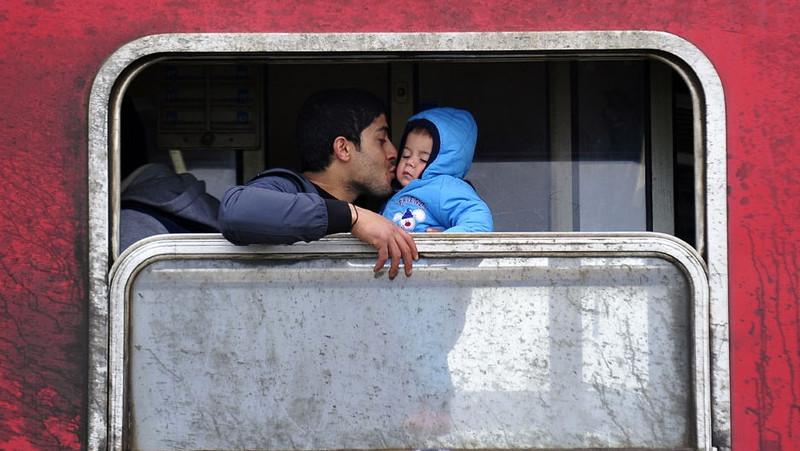 A father kisses his baby boy inside a train outside Vinojug transit centre, near the town of Gevgelija, in the Former Yugoslav Republic of Macedonia. (Credit: UNICEF)