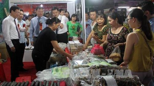Visitors to the fair examine products on display (Photo: VNA)
