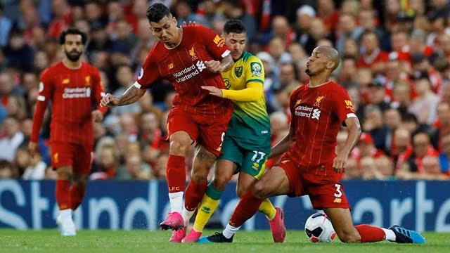 Soccer Football - Premier League - Liverpool v Norwich City - Anfield, Liverpool, Britain - August 9, 2019 Norwich City's Emiliano Buendia in action with Liverpool's Fabinho and Roberto Firmino. REUTERS/Phil Noble