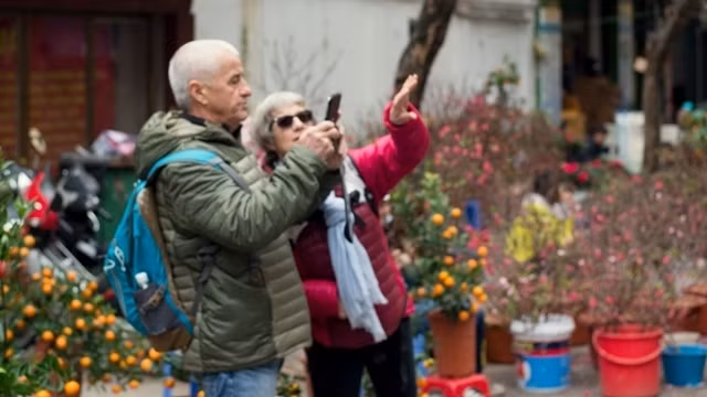 Foreigners enjoy the thriving atmosphere of Tet preparations on Hanoi’s streets.