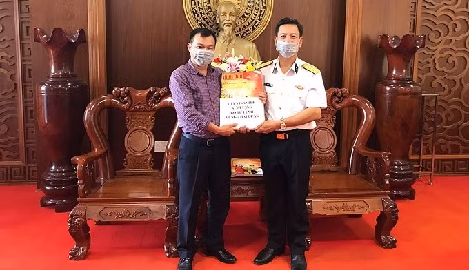 The political chairman of the Navy Region 2 High Command Do Hong Duyen (right) receives copies of spring edition of Nhan Dan Newspaper.