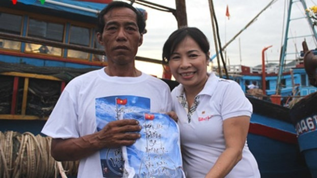 Calligrapher Ai Diep presents a T-shirt to a fisherman (Source: VOV)