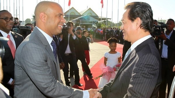 Haitian Prime Minister Laurent Lamothe receives Prime Minister Nguyen Tan Dung (R) at the Toussaint Louveture Airport (Source: VNA).