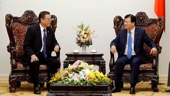 Deputy Prime Minister Trinh Dinh Dung (R) meets with President of Devnet Japan Fumiyasu Akegawa on October 21 (Photo: VNA)