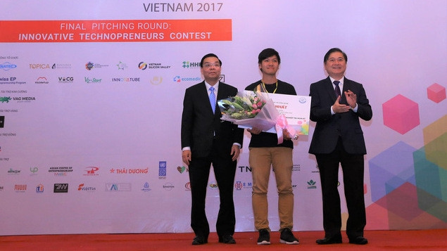 Minister of Science and Technology Chu Ngoc Anh (L) grants the first prize to the winner of the Techfest 2017's contest