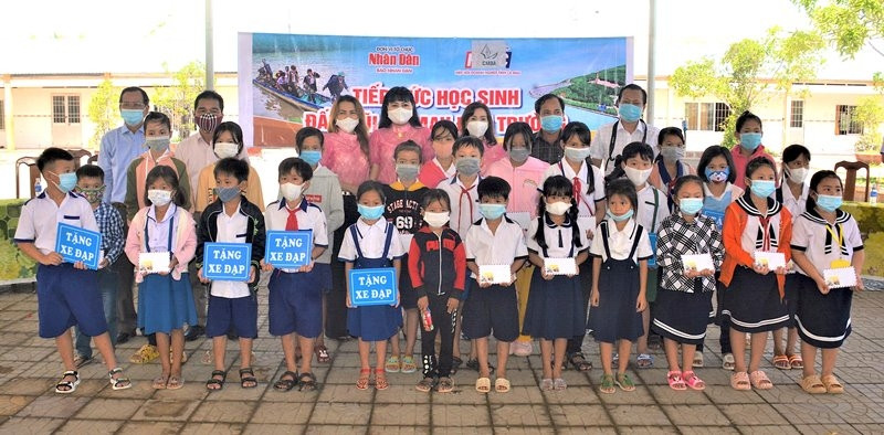 Representatives of Nhan Dan Newspaper in Can Tho and sponsors present scholarships to needy students in Phu Tan district.