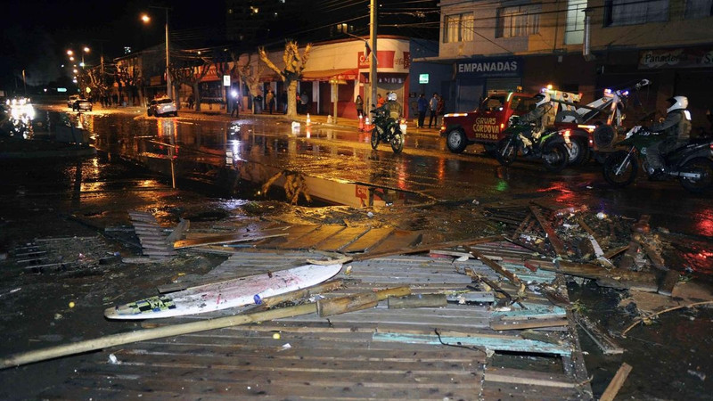 Police patrol a debris strewn street in Valparaiso, Chile after a tsunam, caused by an earthquake hit the area. 