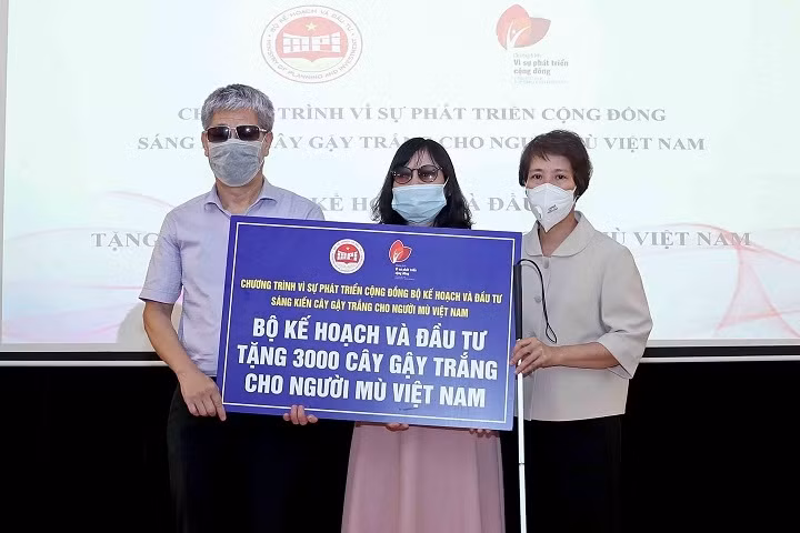 Deputy Minister of Planning and Investment Nguyen Thi Bich Ngoc (R) presents a token of 3,000 white canes to the Vietnam centre for rehabilitation training for the blind on June 22. (Photo: baodautu.vn)