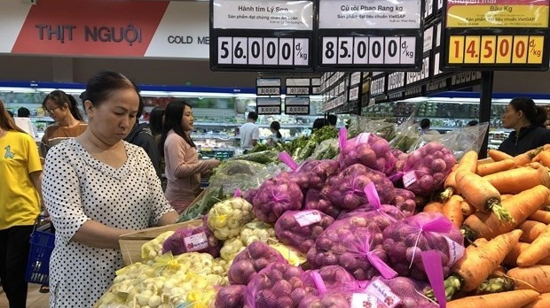 Consumers shop at a supermarket (Photo: VNA)