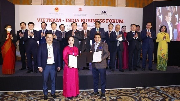 National Assembly Chairman Vuong Dinh Hue witnesses the exchange of cooperation deals between Vietnamese and Indian businesses at the event (Photo: VNA)