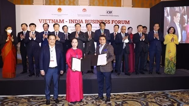 National Assembly Chairman Vuong Dinh Hue witnesses the exchange of cooperation deals between Vietnamese and Indian businesses at the event (Photo: VNA)