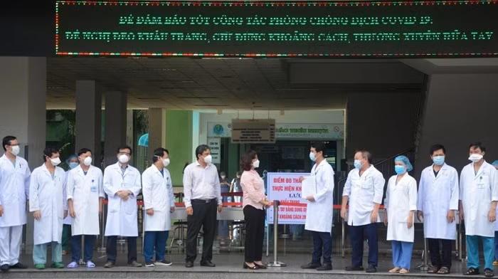 Officials from the Health Department of Da Nang hand over the decision to end medical isolation on the Danang Hospital, Da Nang, August 25, 2020. (Photo: VNA)