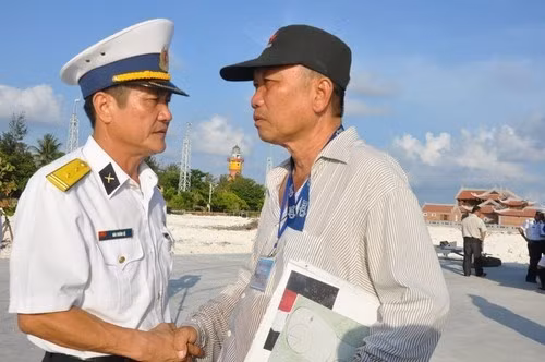 Nguyen Ngoc Lap (right) does handshake and thanks a soldier on Son Ca island. (Credit: thanhnien.com.vn)