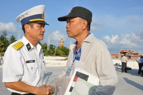 Nguyen Ngoc Lap (right) does handshake and thanks a soldier on Son Ca island. (Credit: thanhnien.com.vn)