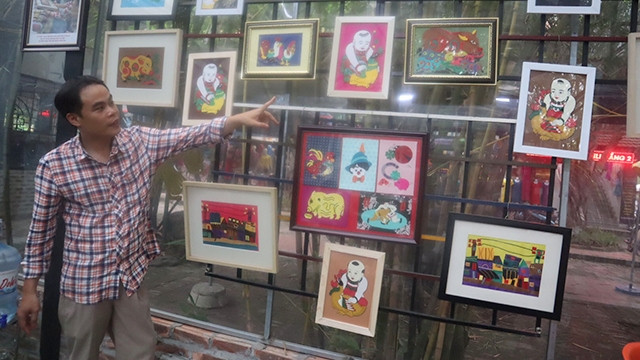 Le Viet Cuong introducing paintings made from fabric scraps by Vun Art members (Photo: NDO/ Hong Trang)