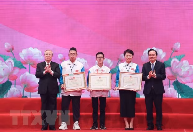 Permanent Member of the Party Central Committee’s Secretariat Tran Quoc Vuong and Minister of Education and Training Phung Xuan Nha present the first prizes of the contest “Youth study and follow the Ho Chi Minh thought, morality and lifestyle”. (Photo: VNA)