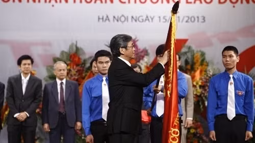Politburo member Dinh The Huynh pins the Labour Hero order, second class, to the traditional flag of the newspaper (Photo: www.tienphong.vn)