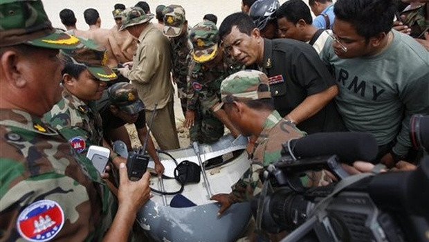 Soldiers gather around a part of a crashed helicopter retrieved from a pond, a site of an helicopter crash in Prey Sar village at the outskirt of Phnom Penh, Cambodia. (Source:AP) 