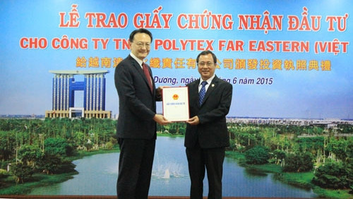 Chairman of Binh Duong provincial People's Committee Tran Van Nam (right) grants the investment certificate to Chairman of the Board of Directors of Polytex Far Eastern Cheng Chen Yu