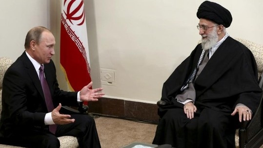 Russian President Vladimir Putin (left) talks with supreme leader of Iran Ayatollah Ali Khamenei. (Credit: AP)