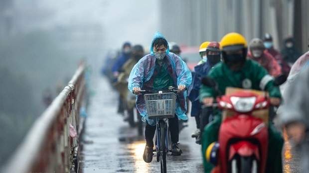 People join traffic in the rain (Photo: VNA)