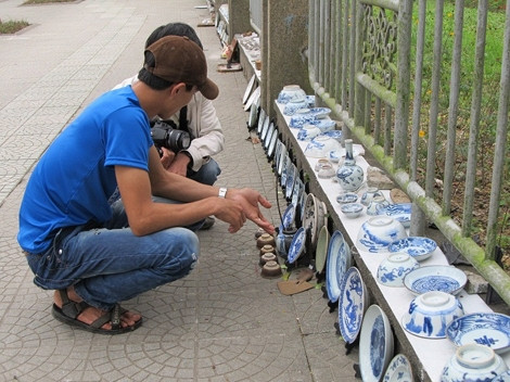 A seller introducing meticulously antiques (Source: petrotimes.vn)