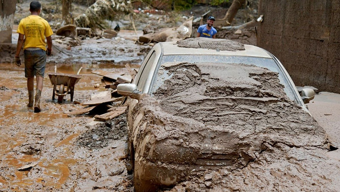 Residents clean the streets after floods hit the area in Raposos, in Minas Gerais state, Brazil , on January 13, 2022. (Photo: Reuters)