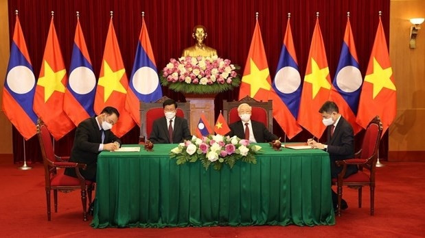 Party General Secretary Nguyen Phu Trong and General Secretary of the Lao People’s Revolutionary Party (LPRP) Central Committee and President of Laos Thongloun Sisoulith witness the signing of a cooperation agreement for 2021 - 2025 between the Party Central Committee's Office of Vietnam and the LPRP Central Committee's Office. (Photo: VNA)