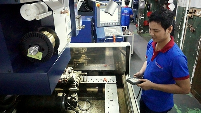 Workers at Duy Khanh Mechanical Co., Ltd. in Ha Thanh ward, Tan Phu district, Ho Chi Minh City, control tools for producing precision mechanical products. (Credit: NDO/Duong Hong Lam)