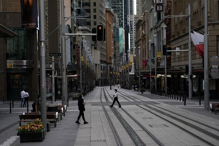 People in protective face masks walk through the quiet city centre during a lockdown to curb the spread of a coronavirus disease (COVID-19) outbreak in Sydney, Australia, July 28, 2021. (Photo: Reuters)
